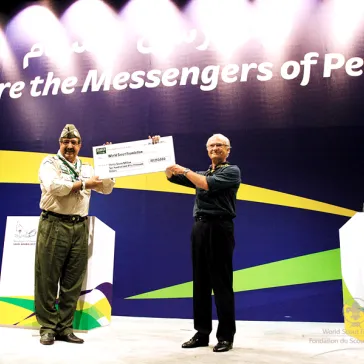 HH Prince Faisal hands-over the check to His Majesty.